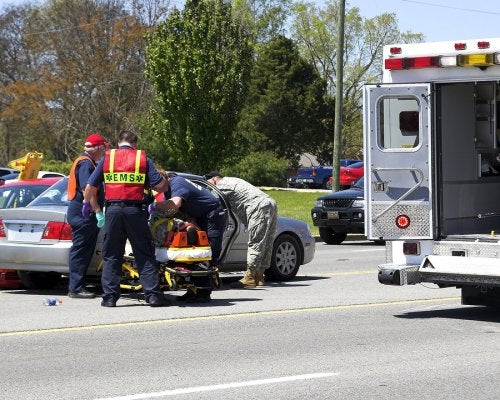 A man receives assistance from an ambulance due to injuries caused by car accident in Riverside, California.