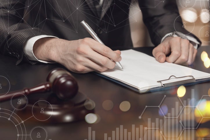 Man in a suit writing on paper representing a Government Liability Attorney in Riverside, CA