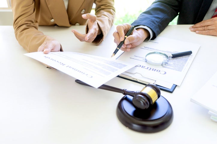A man & woman are signing documents representing a government liability attorney in Riverside, CA