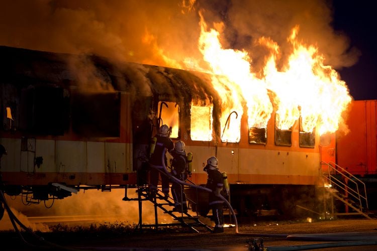 Firemen extinguish a train fire at night in Riverside, California